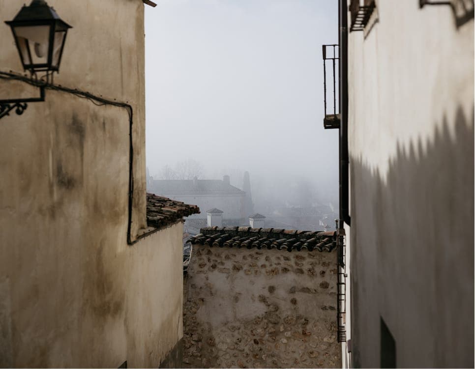 Misty Chinchón rooftops seen from narrow lane
